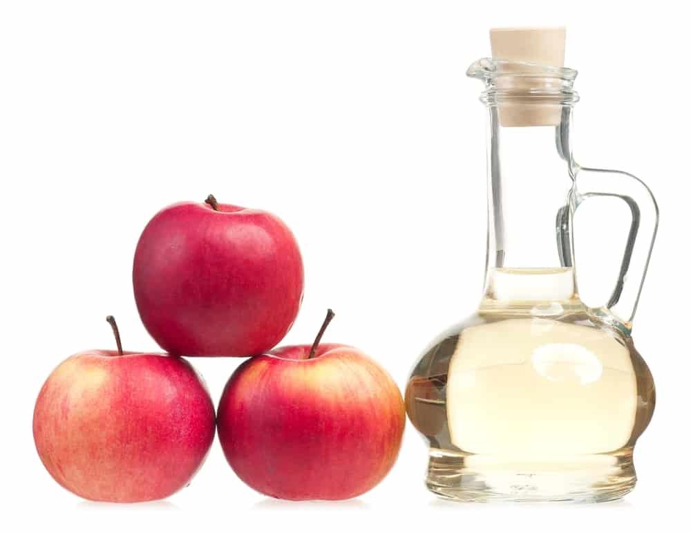 Apple vinegar in the glass bottle with fresh apples isolated on white background