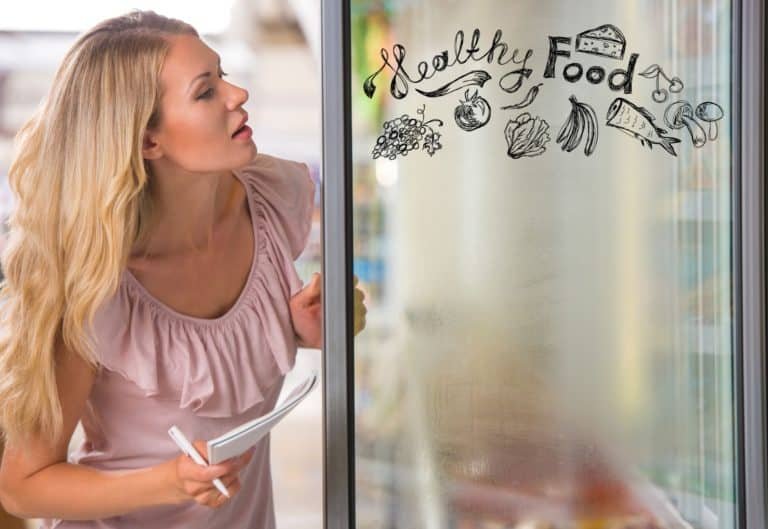 Young pretty woman thinking of healthy food while shopping at grocery store