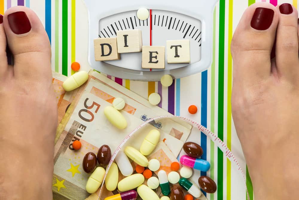 Bathroom scale with pills and money, dial with lines no numbers