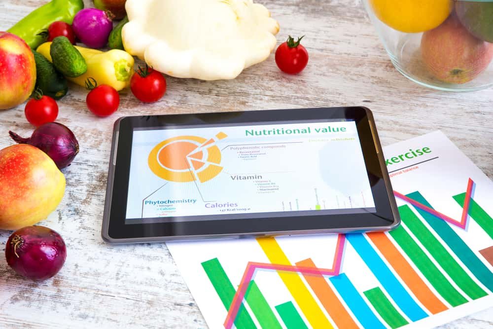 Organic food and a Tablet PC showing information about healthy nutrition and phytochemical composition.