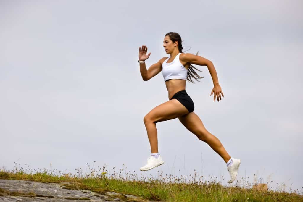 Determined Athlete Running On Mountain Against Sky