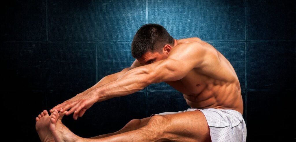 Close-up of a young Muscular Men as he stretches on the floor