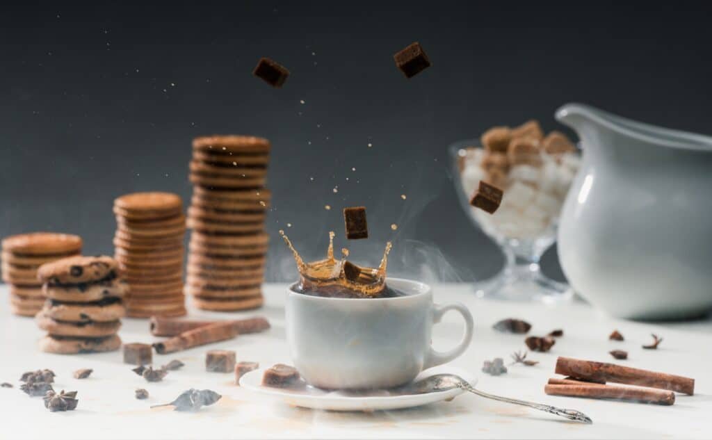 How To Lose Weight Without Dieting: Effective Strategies Explained 5 Brown sugar cubes falling in cup with black coffee on table with cookies and spices