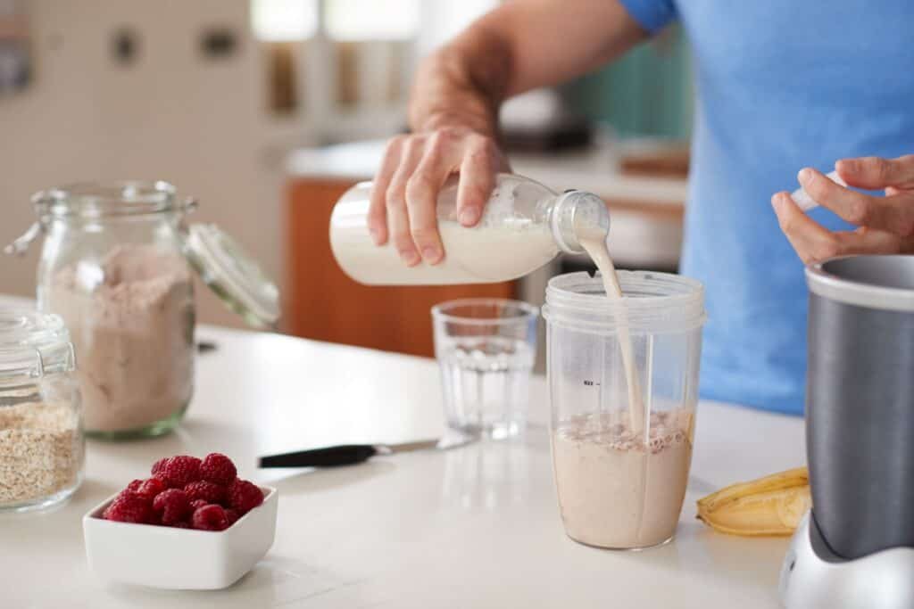 When to Take Workout Supplements: Optimal Timing for Maximum Benefits 4 Close Up Of Man Making Protein Shake After Exercise.
