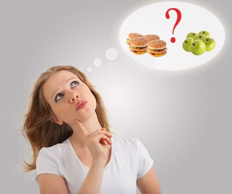 Attractive young woman makes a choice between healthy and unhealthy food