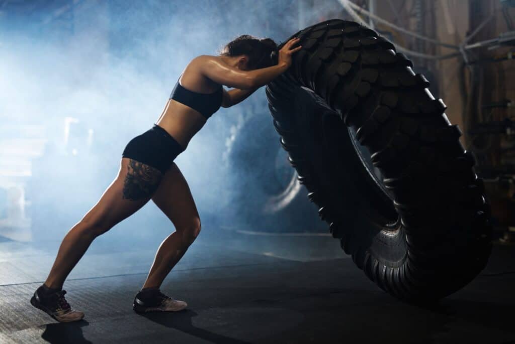 The Benefits of CrossFit: Unlocking Optimal Fitness and Health 3 Strong CrossFit woman athlete flipping tyre