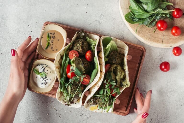 Cropped shot of woman holding falafel with tortillas