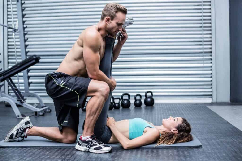 Benefits of Assisted Stretching: Enhancing Flexibility and Wellbeing 2 Muscular couple doing a leg stretching