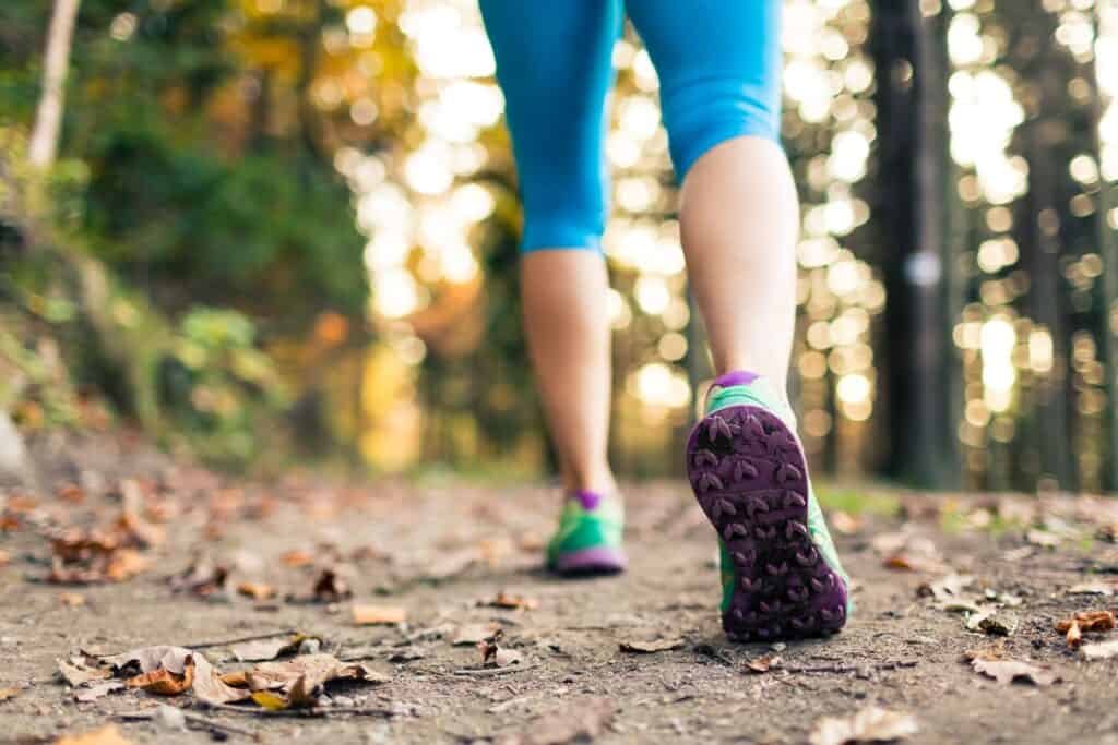 Woman walking and hiking in autumn woods