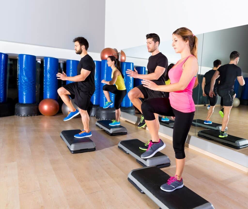 Cardio step dance group at fitness gym training — 