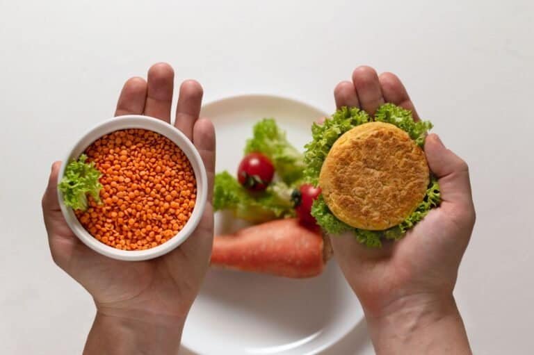 Mans hands hold fresh plant based non meat burger(cutlet)and white bowl with lentil