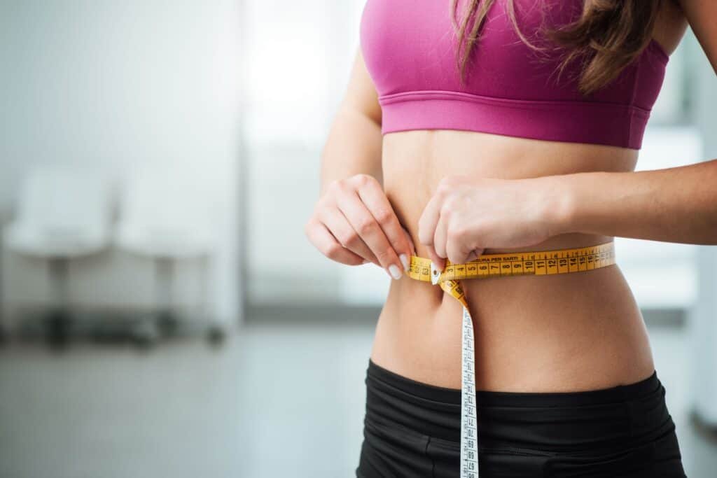 How to Measure Weight Loss Without a Scale: Techniques Beyond Numbers 3 Slim woman measuring her thin waist