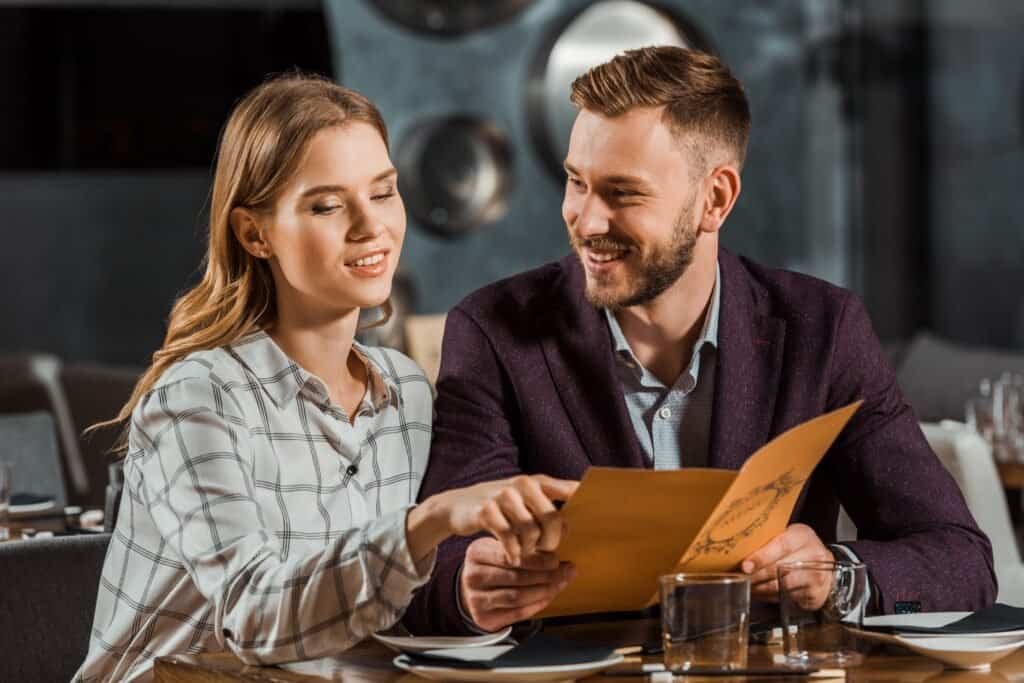 How to Eat Healthy When Eating Out: Proven Strategies for Nutritious Dining 2 Young adult couple looking in menu to order dinner in restaurant