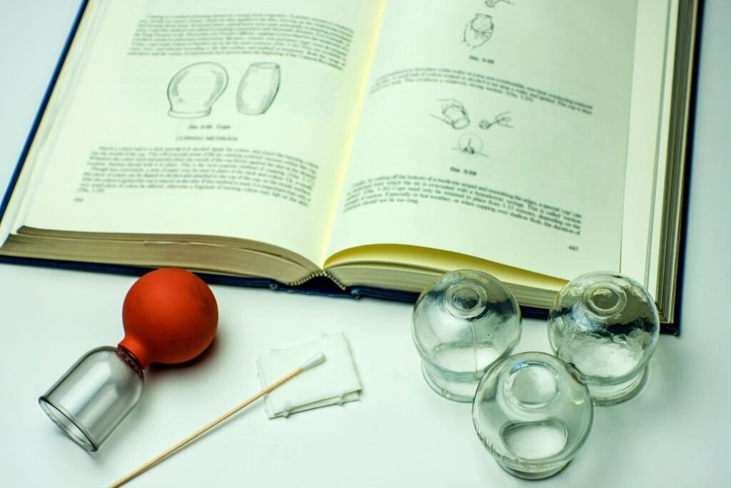 Benefits of Cupping for Weight Loss: Does it Really Work? 2 Cupping glasses with textbook